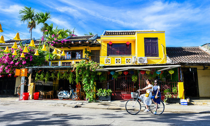 Tourists ride their bicycles in the ancient town of Hoi An